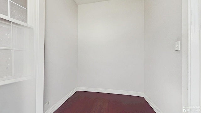 empty room with dark wood-style floors and baseboards