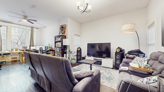 living room featuring ceiling fan with notable chandelier and dark wood-style floors