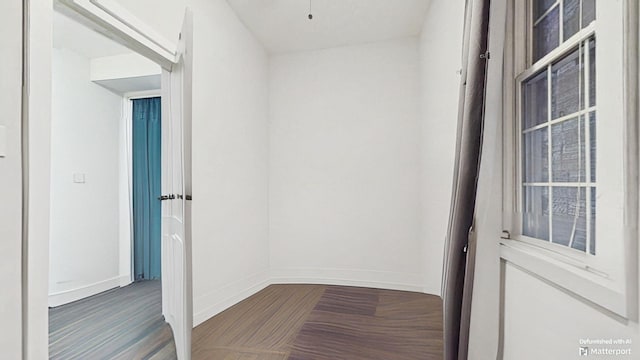 hallway with baseboards and wood finished floors