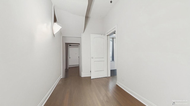 hallway with wood finished floors and baseboards