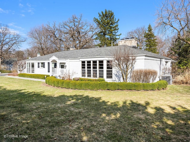 back of property with a lawn, a chimney, and cooling unit