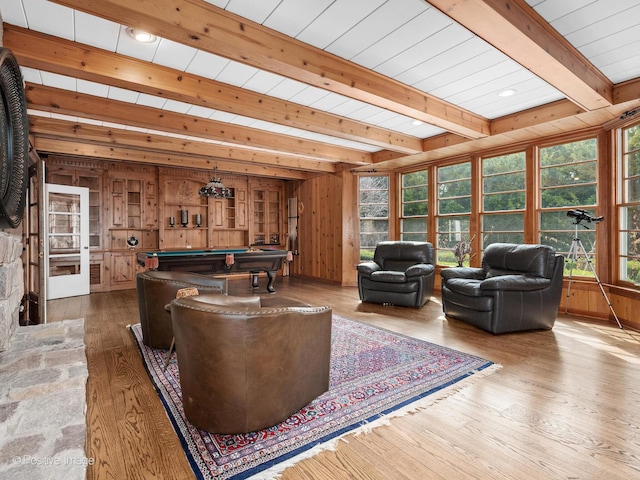 living area featuring wood finished floors, pool table, wooden walls, and beamed ceiling