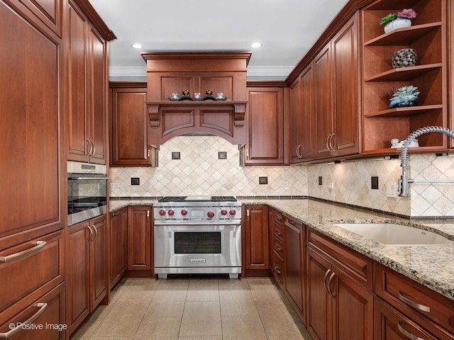 kitchen with stainless steel appliances, open shelves, light stone counters, and a sink