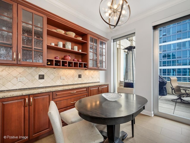 dining area with crown molding, light tile patterned floors, and a notable chandelier
