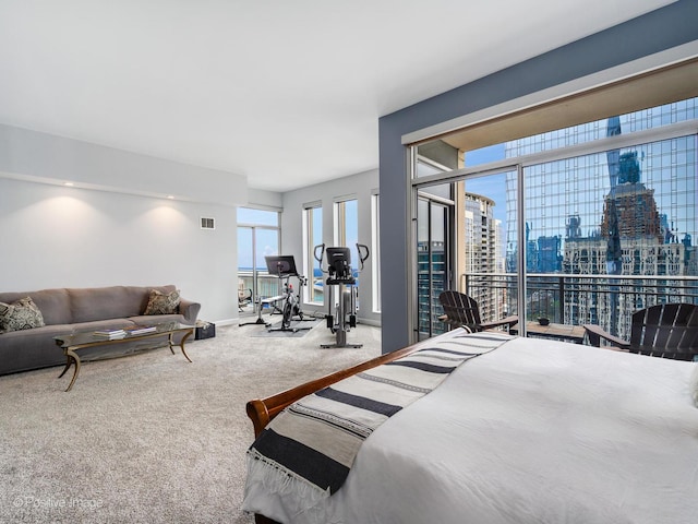 bedroom with a view of city, visible vents, access to exterior, and carpet