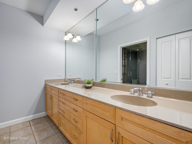 full bathroom featuring a sink, tile patterned floors, baseboards, and double vanity