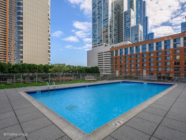 pool with fence and a city view