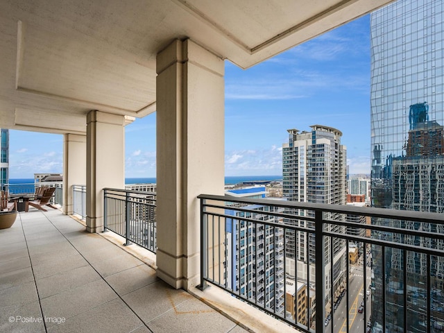 balcony featuring a water view and a city view