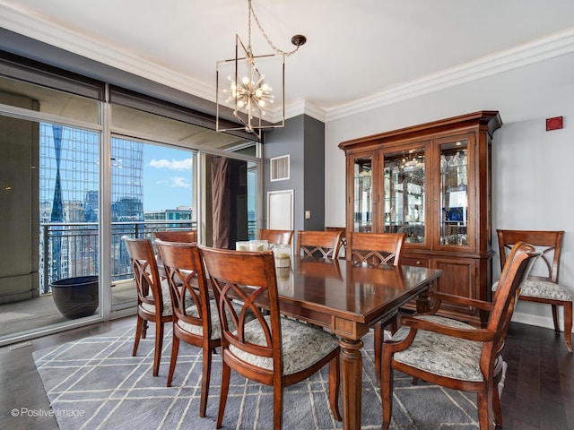 dining room featuring an inviting chandelier, ornamental molding, visible vents, a view of city, and wood finished floors