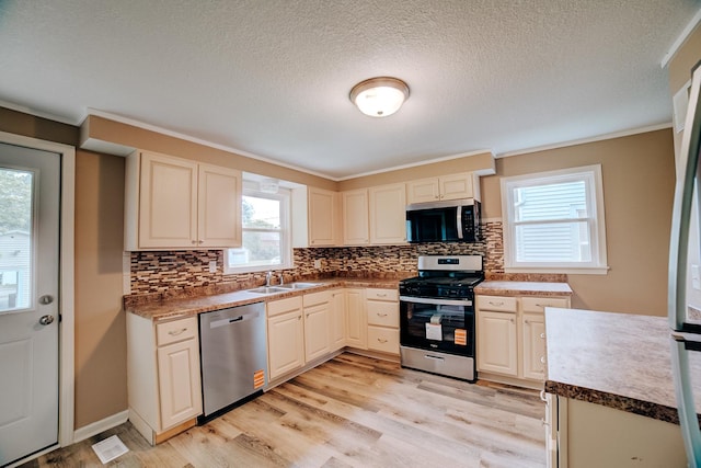 212 E Ash St, Watseka, IL 60970 - kitchen featuring stainless steel appliances, a sink, plenty of natural light, decorative backsplash, and a textured ceiling