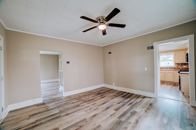 212 E Ash St, Watseka, IL 60970 - spare room with light wood-type flooring, ceiling fan, crown molding, and baseboards