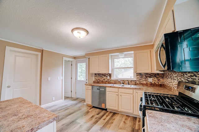 212 E Ash St, Watseka, IL 60970 - kitchen featuring stainless steel appliances, decorative backsplash, light wood-style flooring, a sink, and a textured ceiling