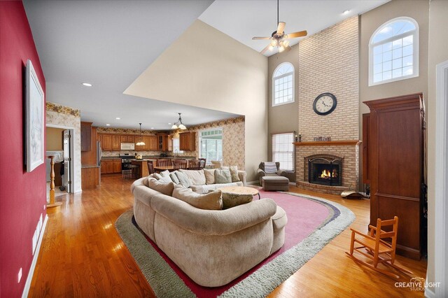 541 Clover Dr, Algonquin, IL 60102 - living room with a towering ceiling, light wood-style floors, ceiling fan, a brick fireplace, and recessed lighting