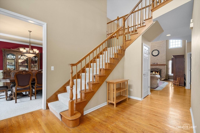 541 Clover Dr, Algonquin, IL 60102 - stairway with a towering ceiling, wood finished floors, baseboards, a brick fireplace, and a chandelier