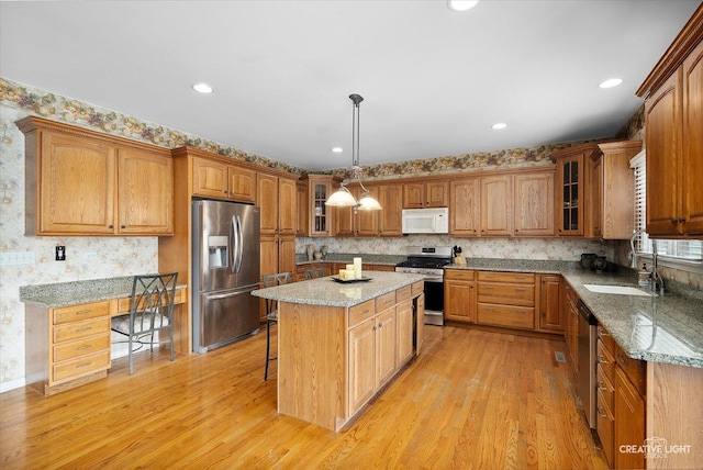 541 Clover Dr, Algonquin, IL 60102 - kitchen featuring stainless steel appliances, a sink, light wood-style flooring, a kitchen island, and a kitchen breakfast bar