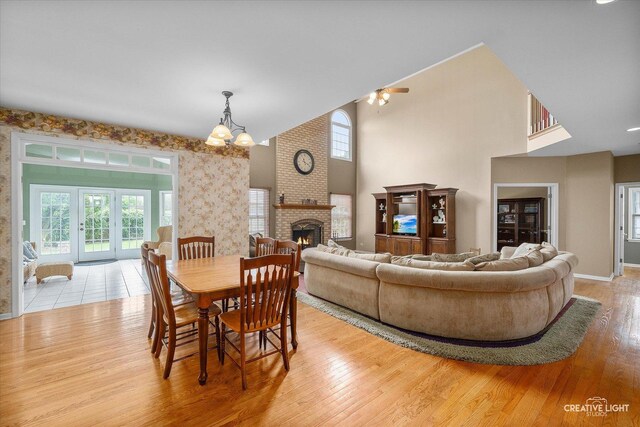 541 Clover Dr, Algonquin, IL 60102 - dining space with wood finished floors, a brick fireplace, baseboards, a chandelier, and french doors