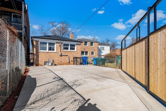 7943 S Blackstone Ave, Chicago, IL 60619 - rear view of house with a chimney, a patio area, fence, and brick siding