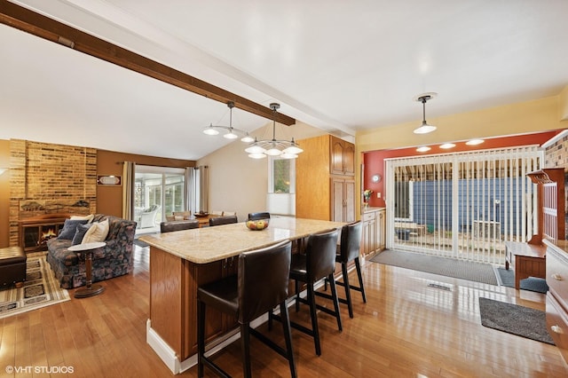111 E Garden Ave, Palatine, IL 60067 - kitchen with light stone counters, open floor plan, decorative light fixtures, a brick fireplace, and hardwood / wood-style flooring