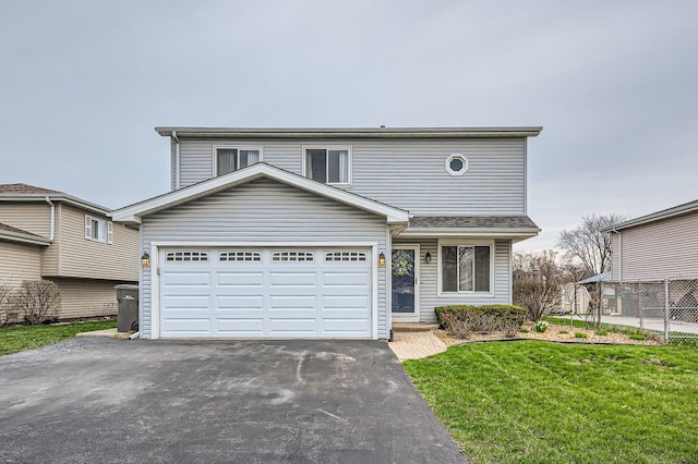 traditional-style home featuring aphalt driveway, a front yard, fence, and a garage