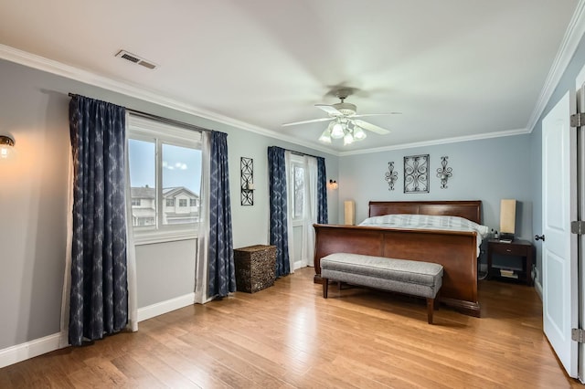 bedroom featuring ornamental molding, visible vents, light wood-style flooring, and baseboards