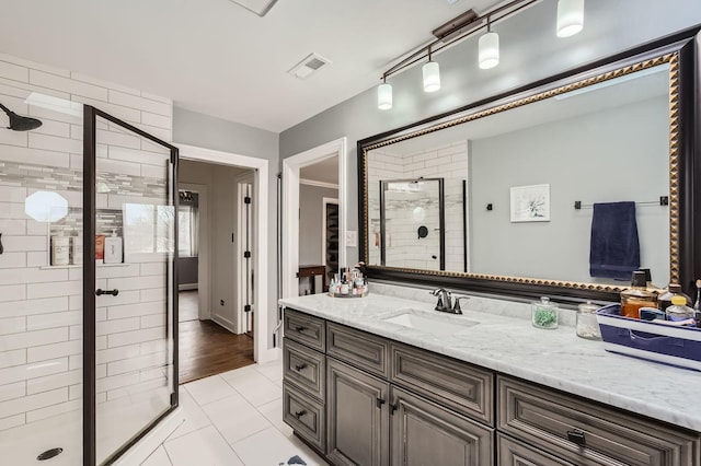 full bath with a stall shower, vanity, tile patterned flooring, and visible vents