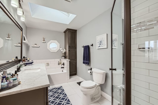 bathroom featuring vanity, tile patterned flooring, toilet, a skylight, and a garden tub