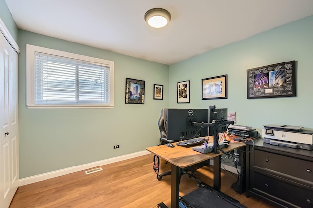 home office featuring light wood finished floors, visible vents, and baseboards
