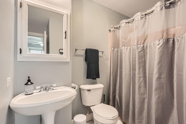full bath with a sink, toilet, and a shower with shower curtain