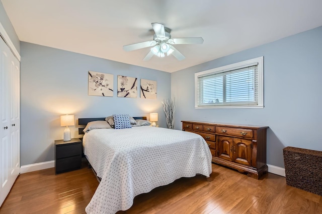bedroom with ceiling fan, a closet, baseboards, and wood finished floors