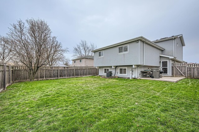 rear view of property with a yard, a fenced backyard, cooling unit, and a patio area