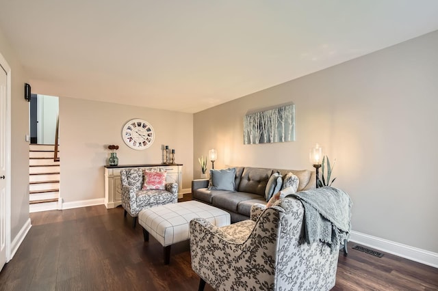 living room with stairs, visible vents, dark wood-style flooring, and baseboards