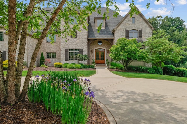 3131 Pepper Creek Bridge Pkwy, Valparaiso, IN 46385 - french country style house with stone siding, french doors, and roof with shingles