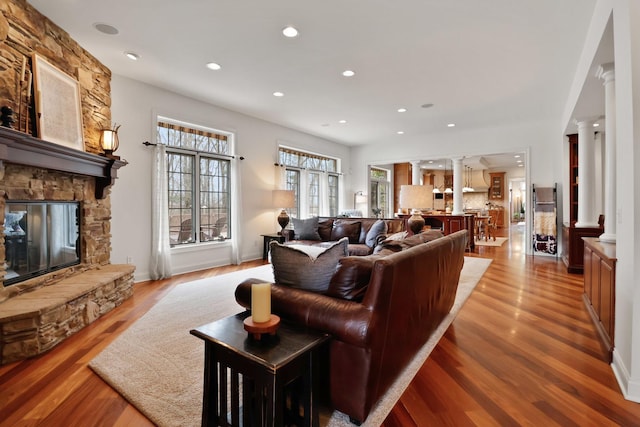 3131 Pepper Creek Bridge Pkwy, Valparaiso, IN 46385 - living room with ornate columns, light wood-style floors, recessed lighting, and a stone fireplace