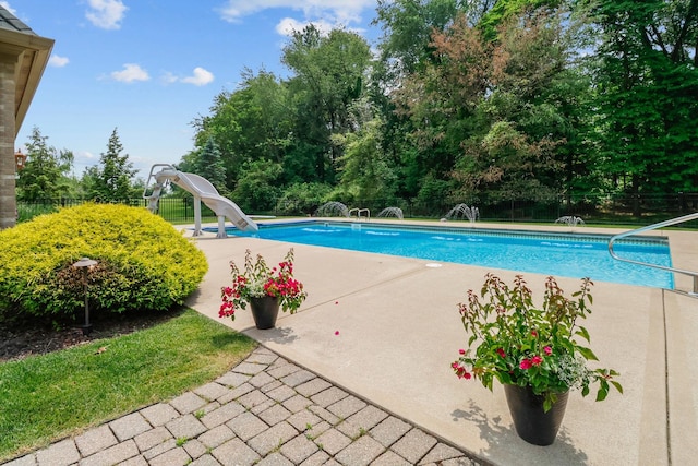 3131 Pepper Creek Bridge Pkwy, Valparaiso, IN 46385 - view of swimming pool featuring a water slide, a patio area, a fenced backyard, and view of wooded area