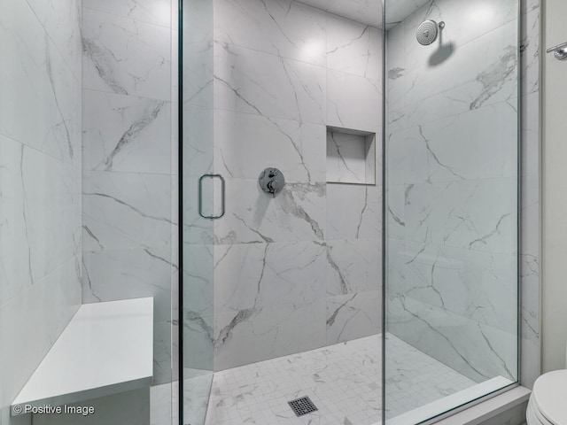 full bath featuring toilet and a marble finish shower