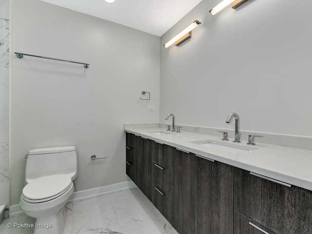 full bath with toilet, baseboards, marble finish floor, and a sink