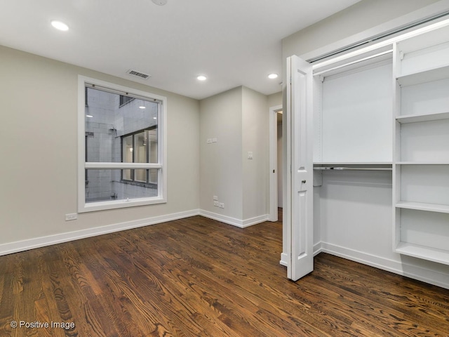 unfurnished bedroom with wood finished floors, visible vents, recessed lighting, and a closet