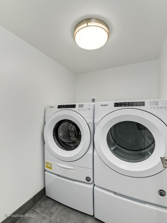 clothes washing area featuring independent washer and dryer, laundry area, and baseboards