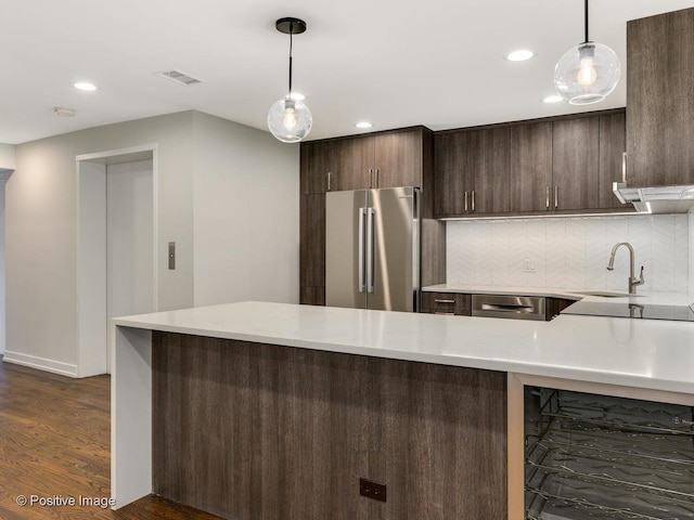 kitchen featuring a sink, visible vents, stainless steel appliances, light countertops, and dark brown cabinets
