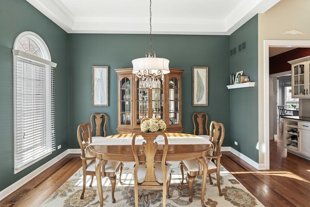 dining room featuring wood finished floors, baseboards, and visible vents