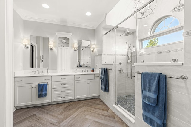 bathroom featuring a sink, ornamental molding, double vanity, and a stall shower