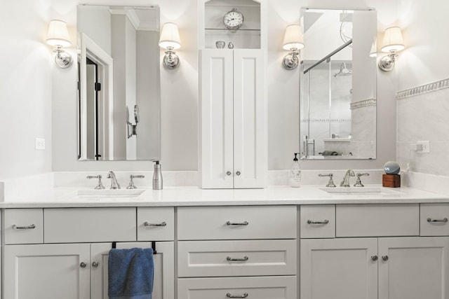 full bathroom with a sink, a shower stall, and double vanity