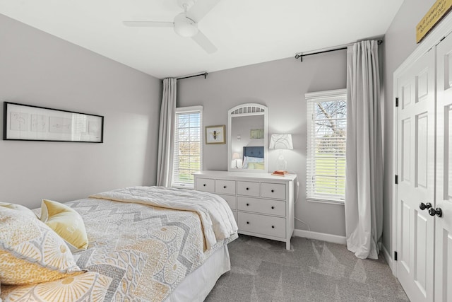 bedroom with light carpet, multiple windows, a closet, and ceiling fan