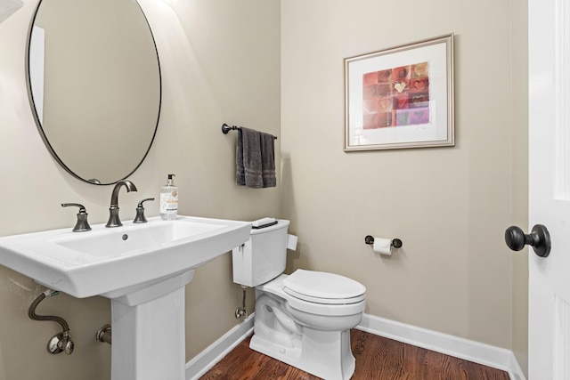 bathroom with baseboards, toilet, and wood finished floors