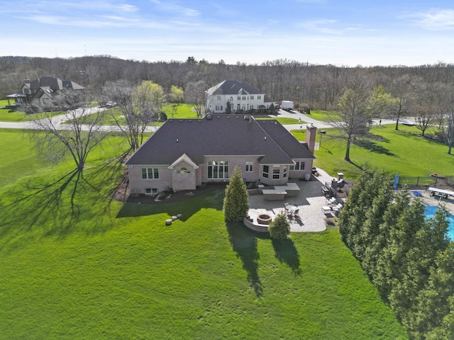 drone / aerial view featuring a wooded view