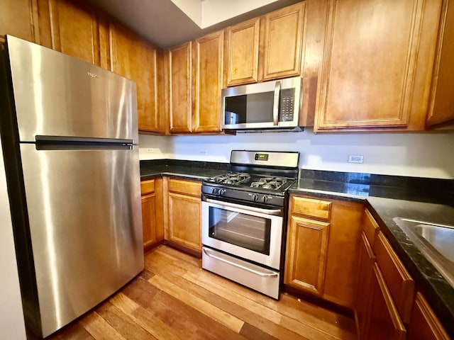4731 S Ingleside Ave Unit C3, Chicago, IL 60615 - kitchen featuring brown cabinetry, appliances with stainless steel finishes, and light wood-style floors