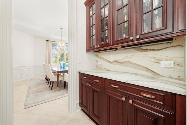 96 S Wynstone Dr, North Barrington, IL 60010 - bar area featuring a chandelier, crown molding, light tile patterned floors, a decorative wall, and a wainscoted wall