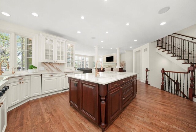 96 S Wynstone Dr, North Barrington, IL 60010 - kitchen featuring light wood finished floors, white cabinetry, light stone countertops, glass insert cabinets, and open floor plan