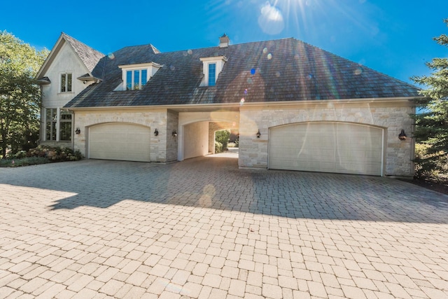 96 S Wynstone Dr, North Barrington, IL 60010 - french country inspired facade with stone siding, decorative driveway, a garage, and a chimney