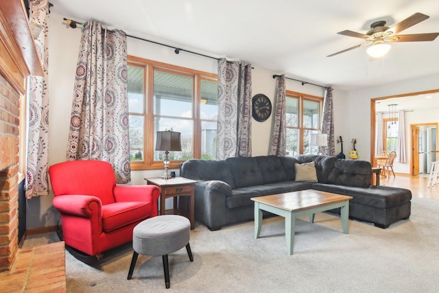 carpeted living area with ceiling fan